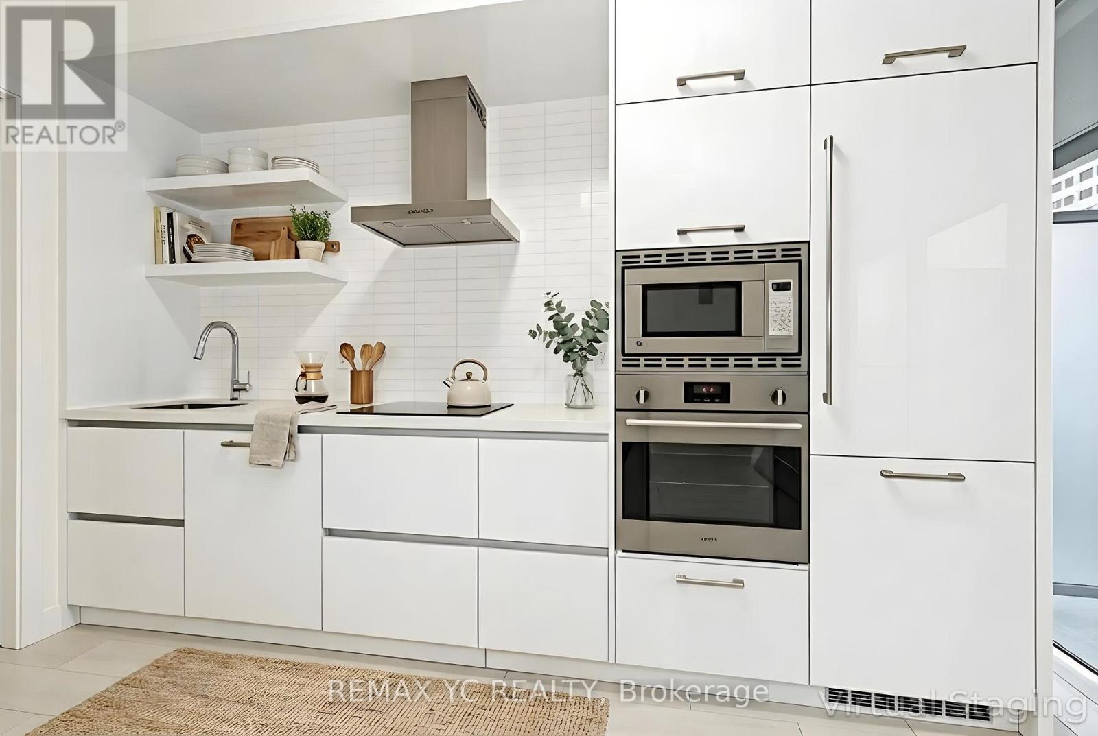 A modern kitchen with white cabinets and stainless steel appliances.