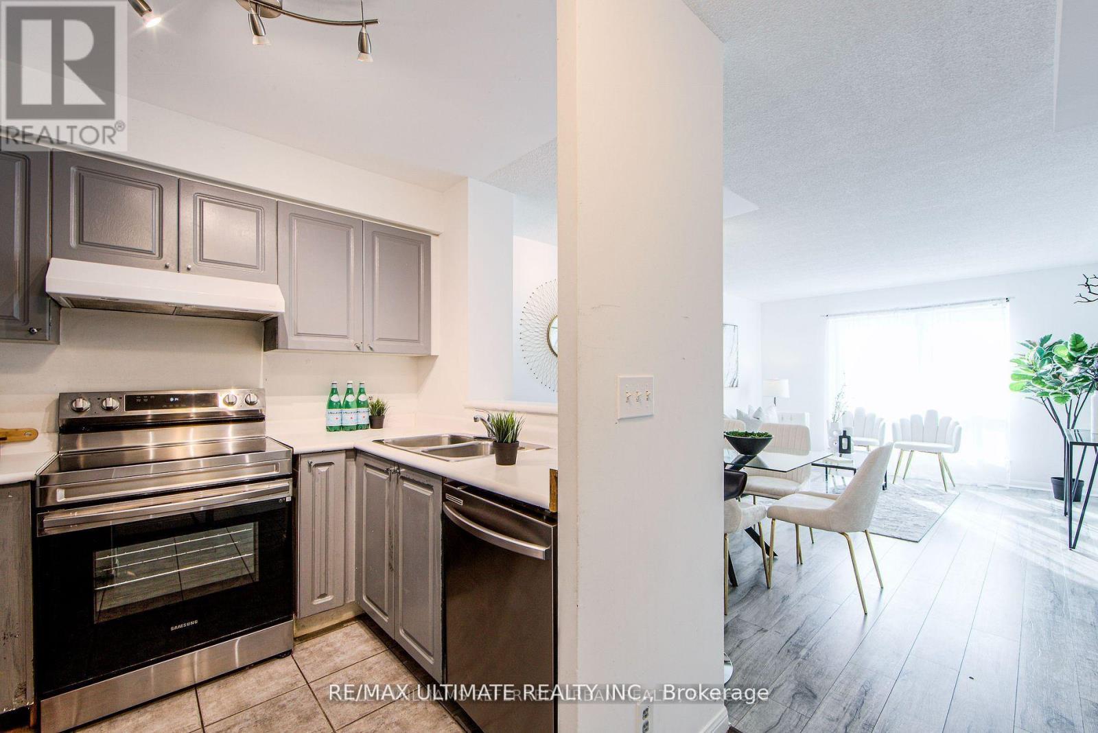 A modern kitchen with a stainless steel oven and a dining area with a table and chairs.