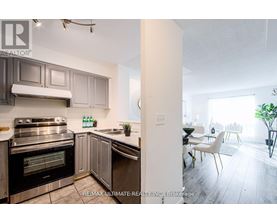 A modern kitchen with a stainless steel oven and a dining area with a table and chairs.