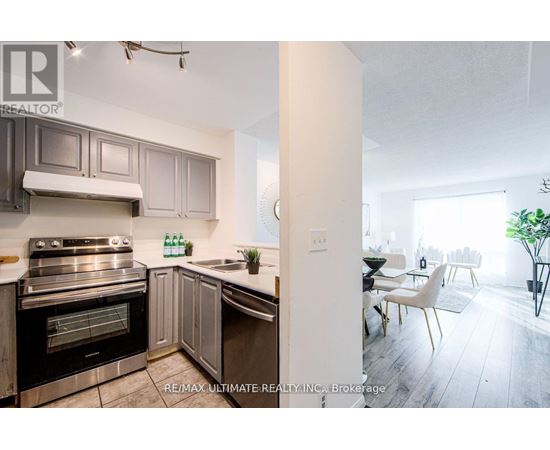 A modern kitchen with a stainless steel oven and a dining area with a table and chairs.