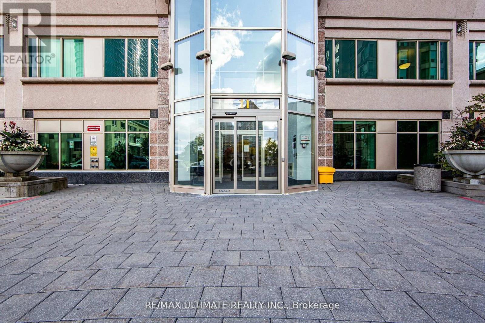 The image shows the entrance to a building with glass doors and windows.