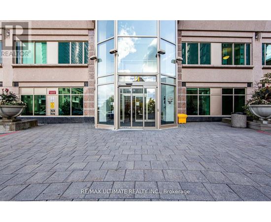 The image shows the entrance to a building with glass doors and windows.