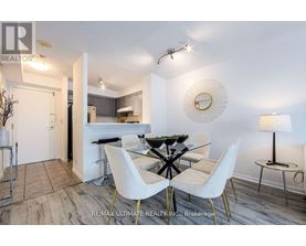 A dining room with a glass table and white chairs.
