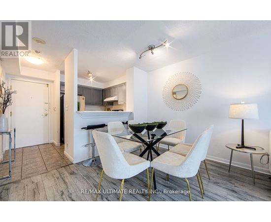 A dining room with a glass table and white chairs.