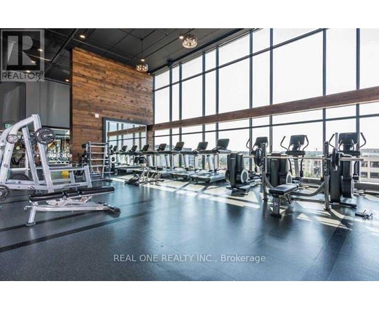 A gym with a variety of equipment including treadmills, weights, and exercise machines.
