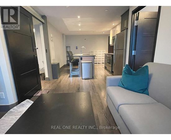 A modern kitchen with black appliances and a dining area with a table and chairs.