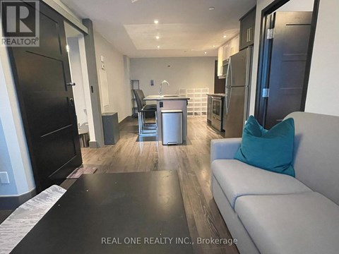A modern kitchen with black appliances and a dining area with a table and chairs.