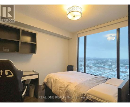 A bedroom with a large bed and a desk with a chair.