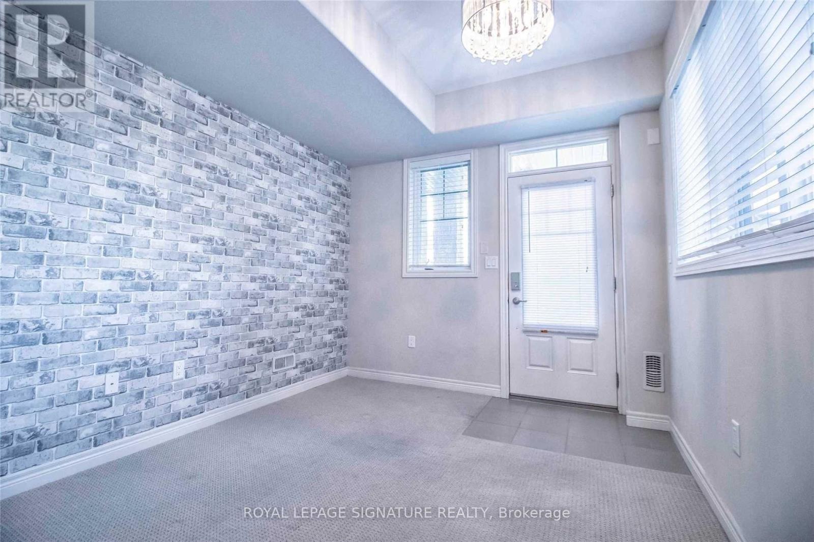 A room with a brick wall and a door.
