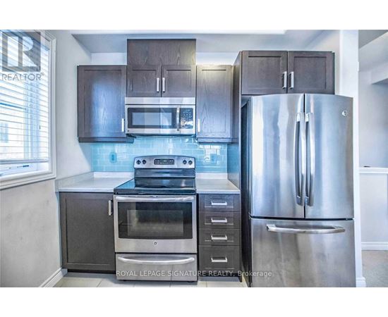 A kitchen with a stainless steel refrigerator, oven, and microwave.