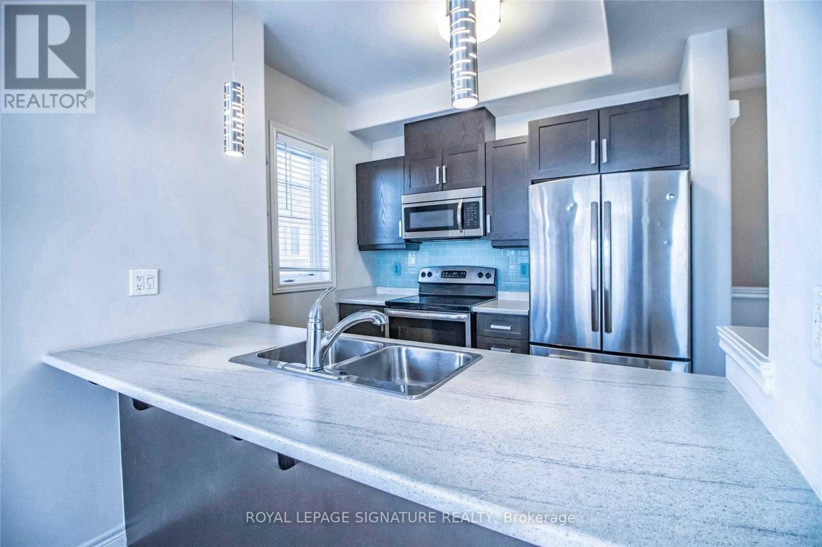 A modern kitchen with stainless steel appliances and a large island.