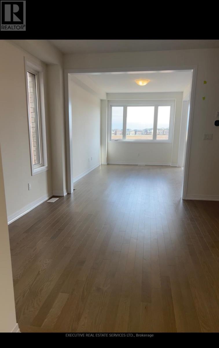 A room with wooden flooring and a large window.