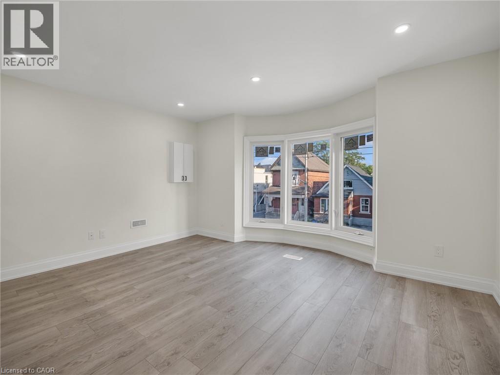 A room with a large window and wooden flooring.