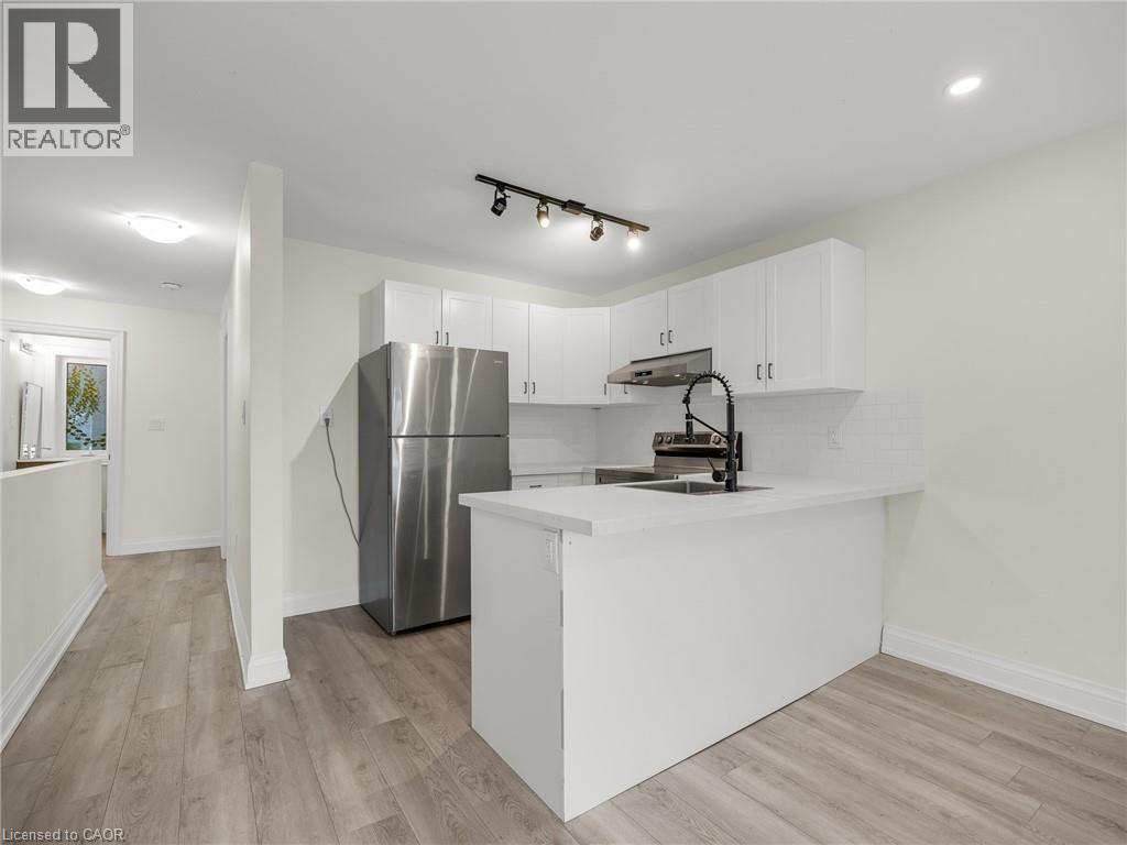 A modern kitchen with white cabinets and a stainless steel refrigerator.