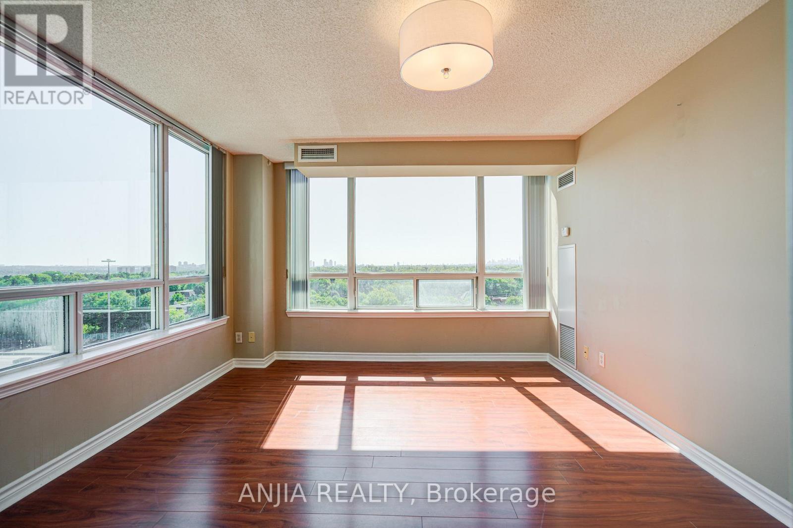 A room with a large window and wooden flooring.