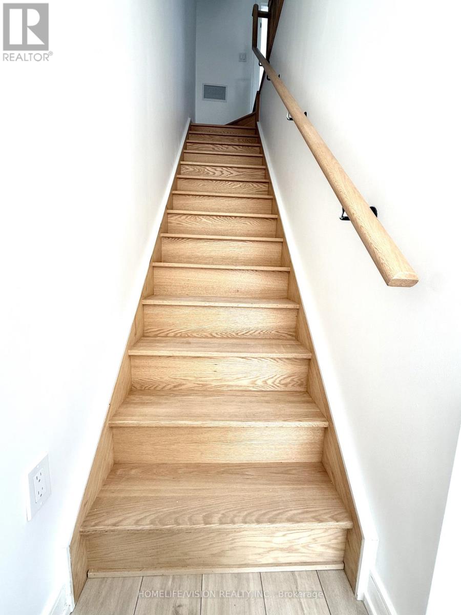 A long flight of wooden stairs with a handrail on the side.