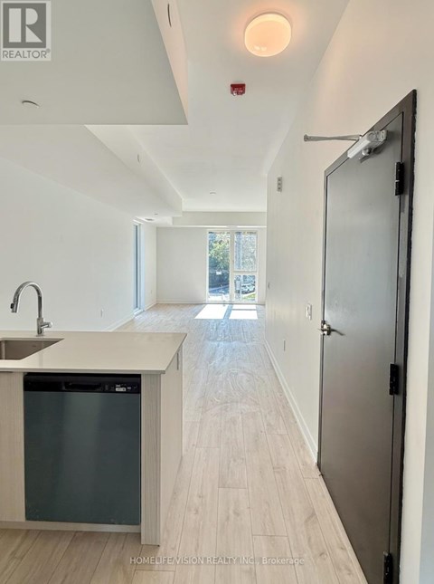 A modern kitchen with a sink and a refrigerator.