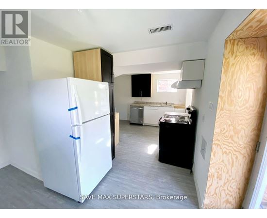 A white fridge in a kitchen with a black dishwasher.