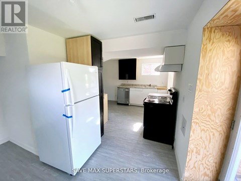 A white fridge in a kitchen with a black dishwasher.