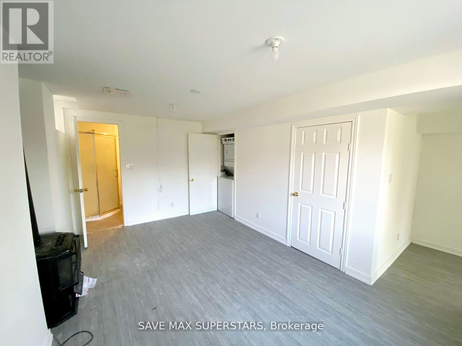 A spacious room with a flat screen TV and a door on the left.