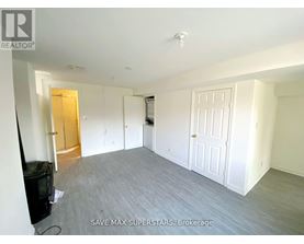 A spacious room with a flat screen TV and a door on the left.