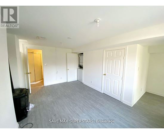 A spacious room with a flat screen TV and a door on the left.