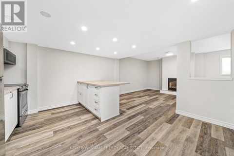 A spacious kitchen with white cabinets and a wooden floor.