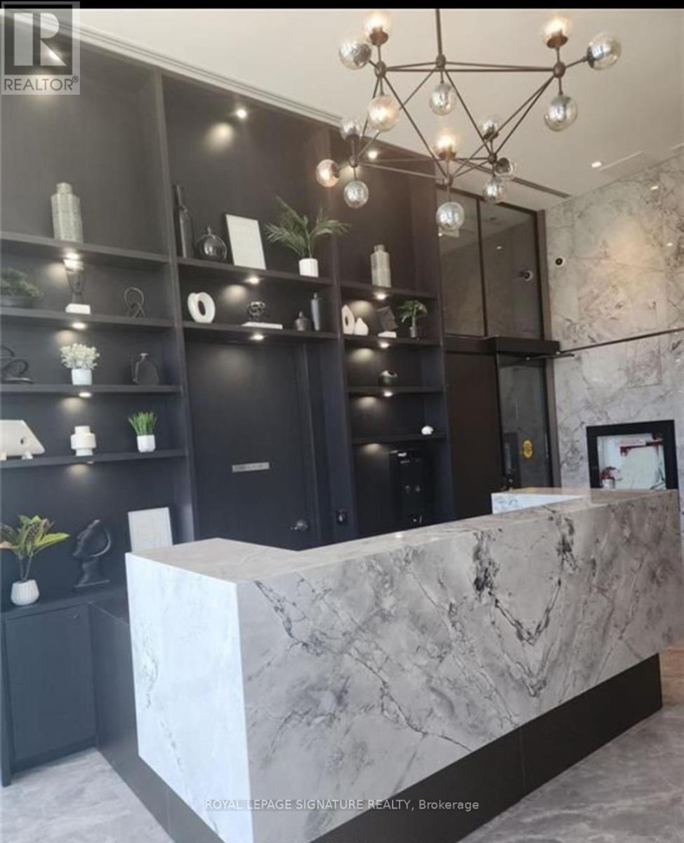 A reception area with a marble counter and a chandelier.