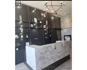 A reception area with a marble counter and a chandelier.