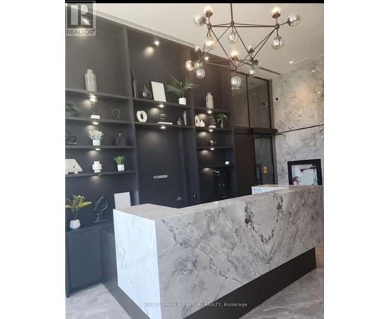 A reception area with a marble counter and a chandelier.