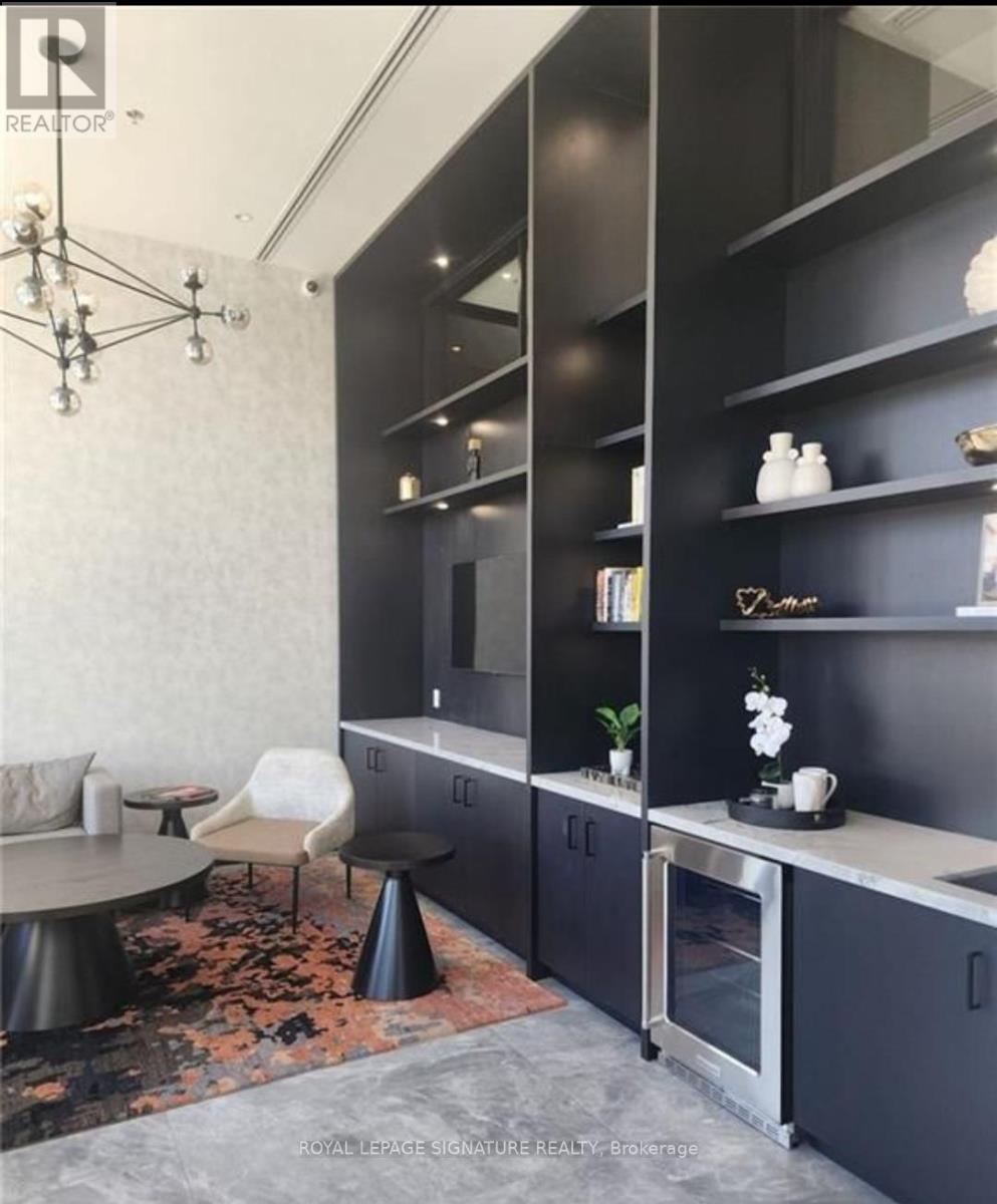 A modern kitchen with black cabinets and a grey floor.