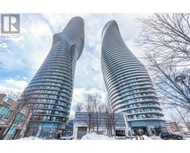 Two tall buildings with curved glass facades stand side by side.