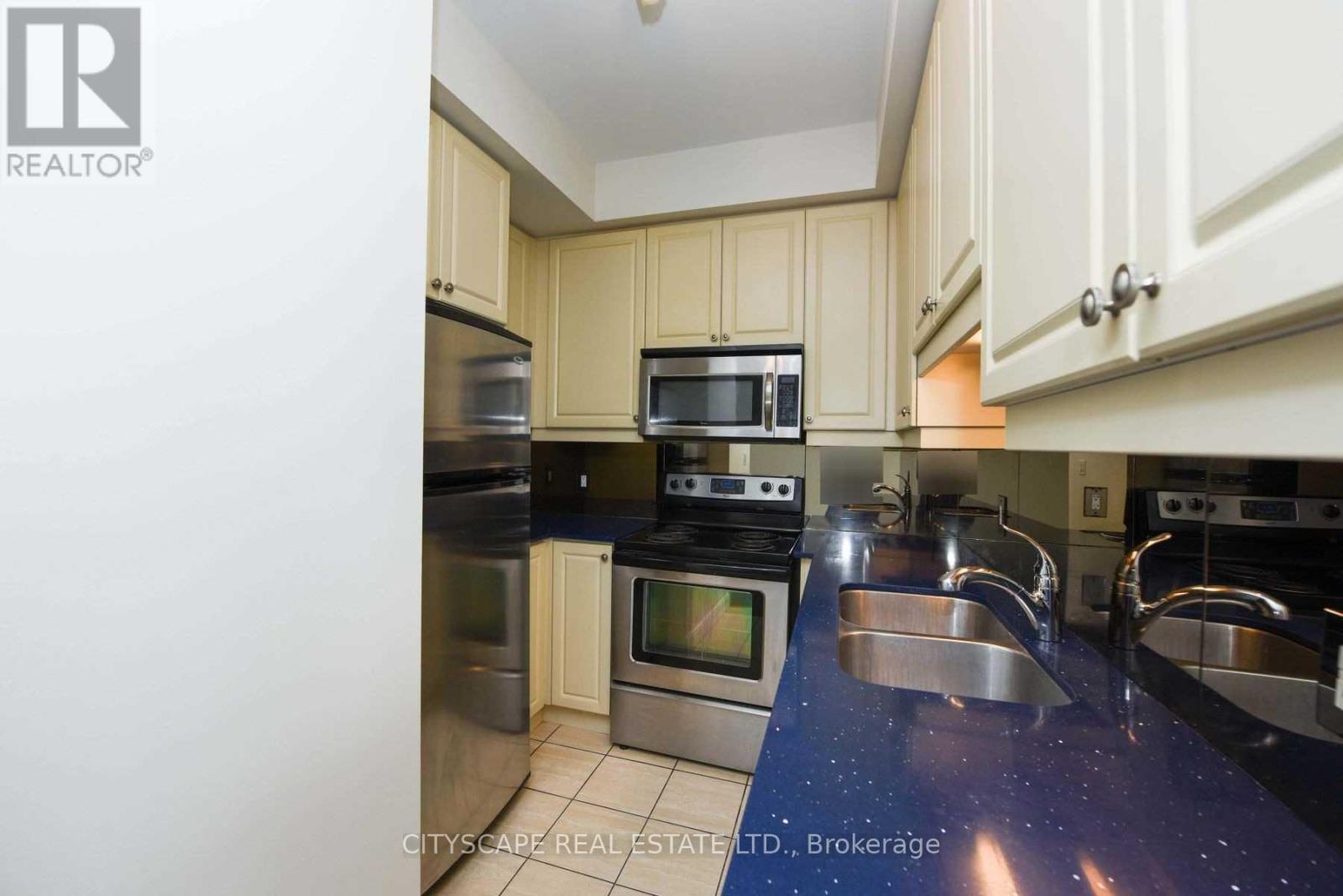 A kitchen with a blue counter top and stainless steel appliances.