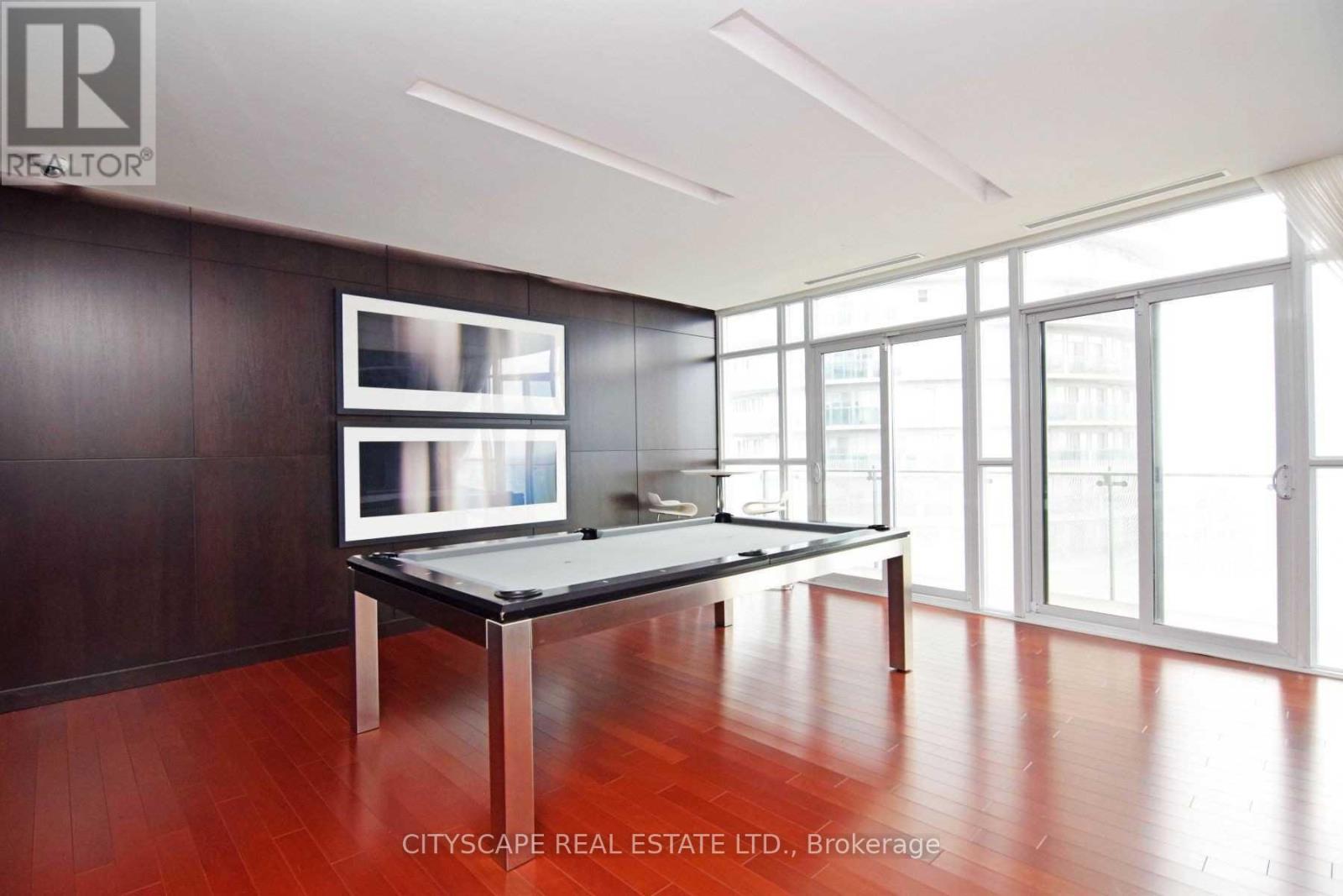 A room with a pool table and a tv on the wall.
