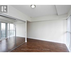 A spacious room with wood flooring and a sliding glass door.