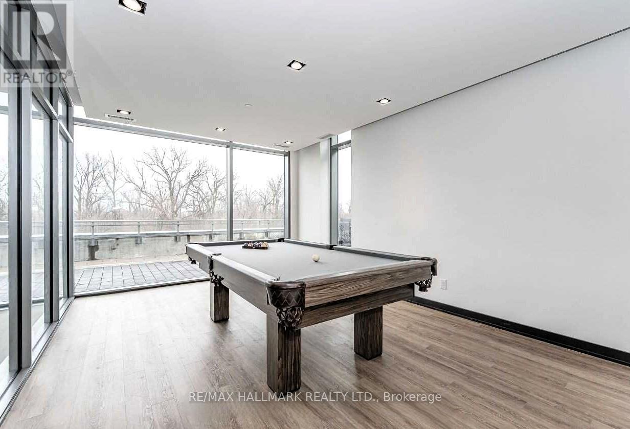 A pool table in a room with a view of trees outside the window.