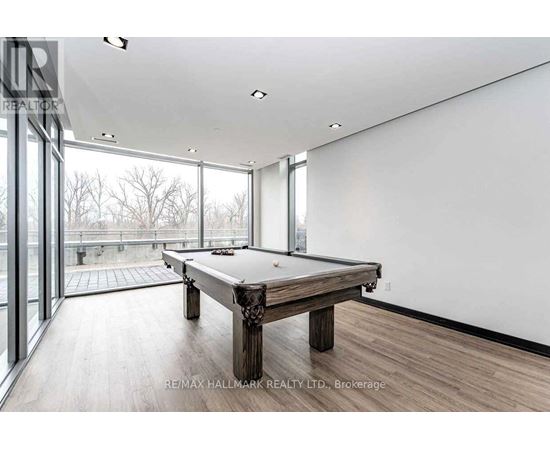 A pool table in a room with a view of trees outside the window.