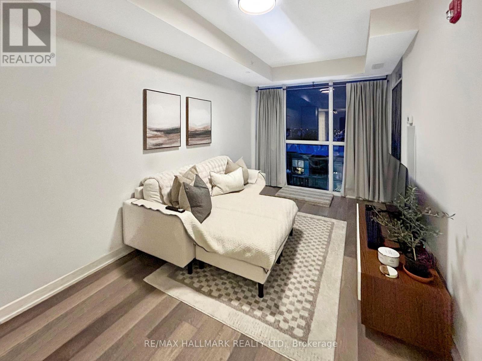 A bedroom with a large bed and a view of the city at night.