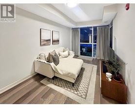 A bedroom with a large bed and a view of the city at night.