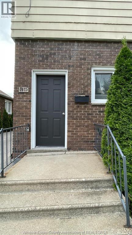 A black door is on the front of a brick house.