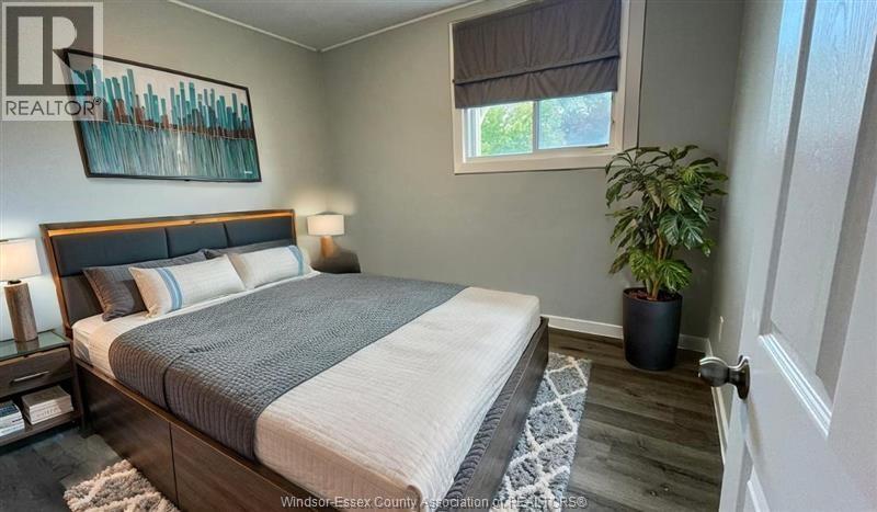 A bedroom with a large bed and a potted plant.