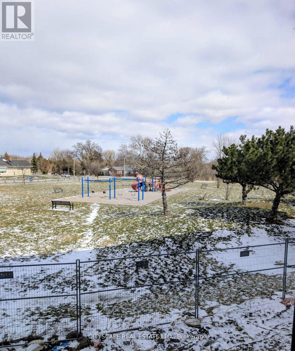 A playground with a slide and a tree in the foreground.