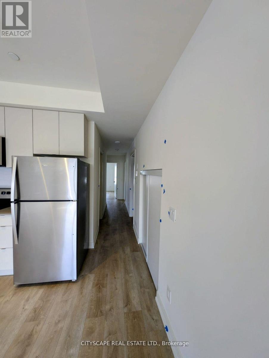 A kitchen with a refrigerator and cabinets in a house.