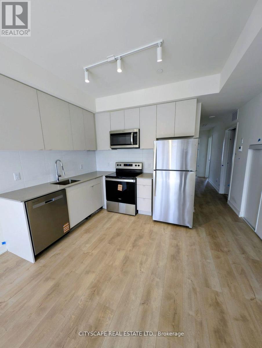 A kitchen with white cabinets and a wooden floor.
