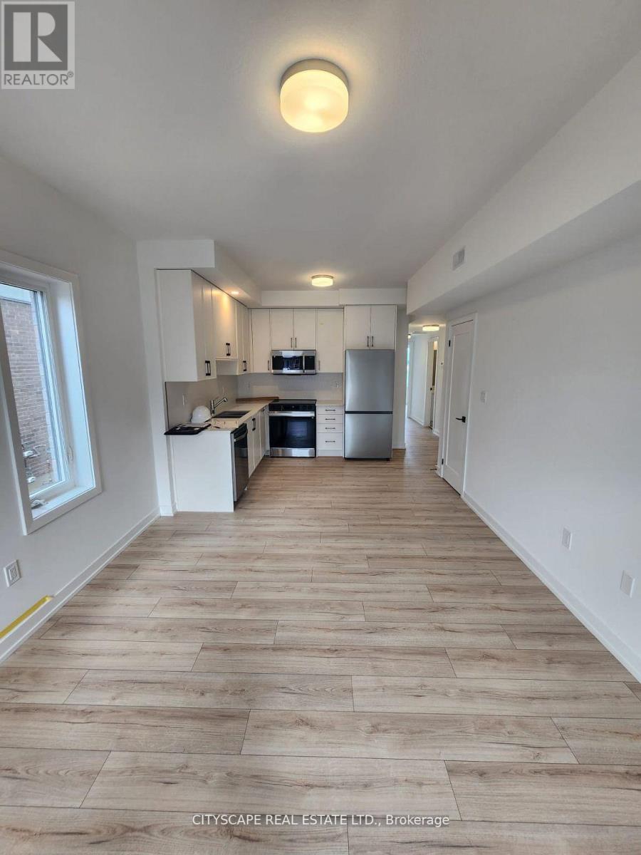A kitchen with white cabinets and a wooden floor.