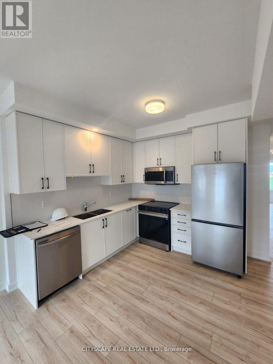 A kitchen with white cabinets and a wooden floor.