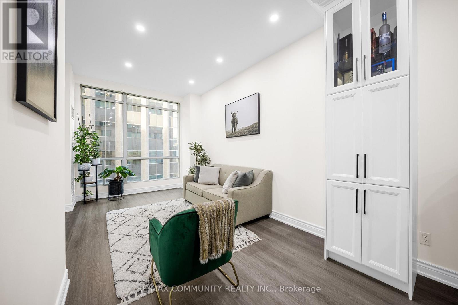 A living room with a green chair and a white couch.