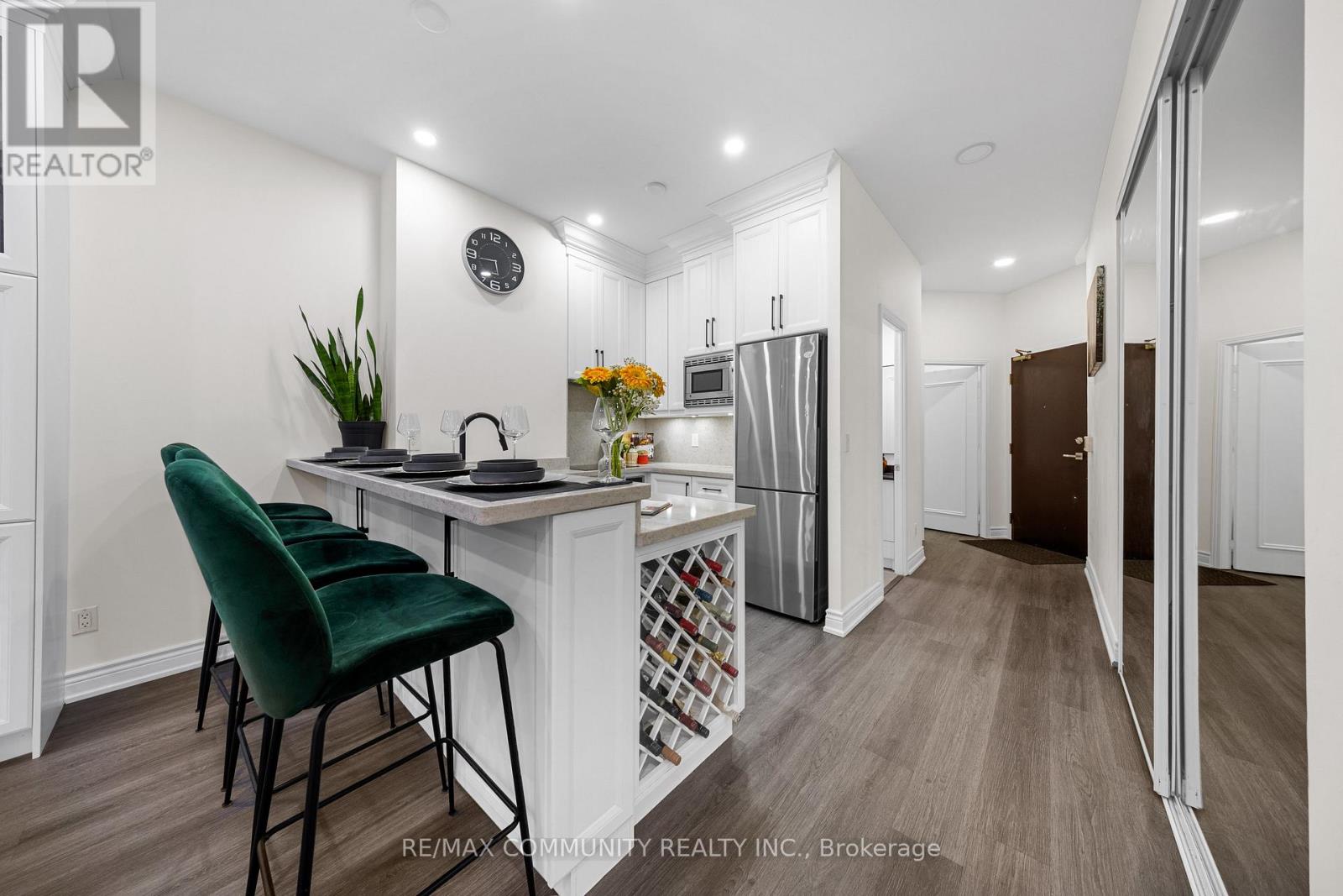 A kitchen with a green chair and a white counter.