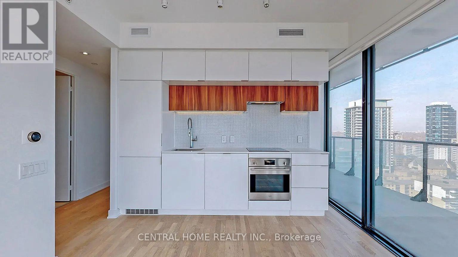A modern kitchen with white cabinets and a stainless steel oven.