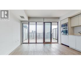 A modern kitchen with white cabinets and a view of the city through the glass doors.